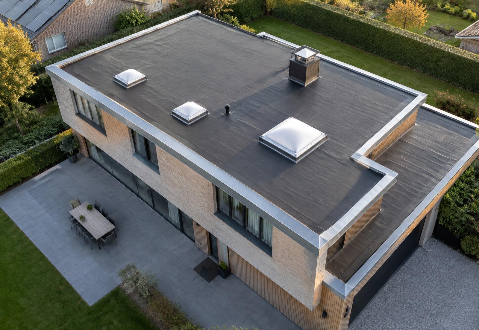 Luchtbeeld van een plat EPDM-dak met lichtkoepels en zinken dakrand