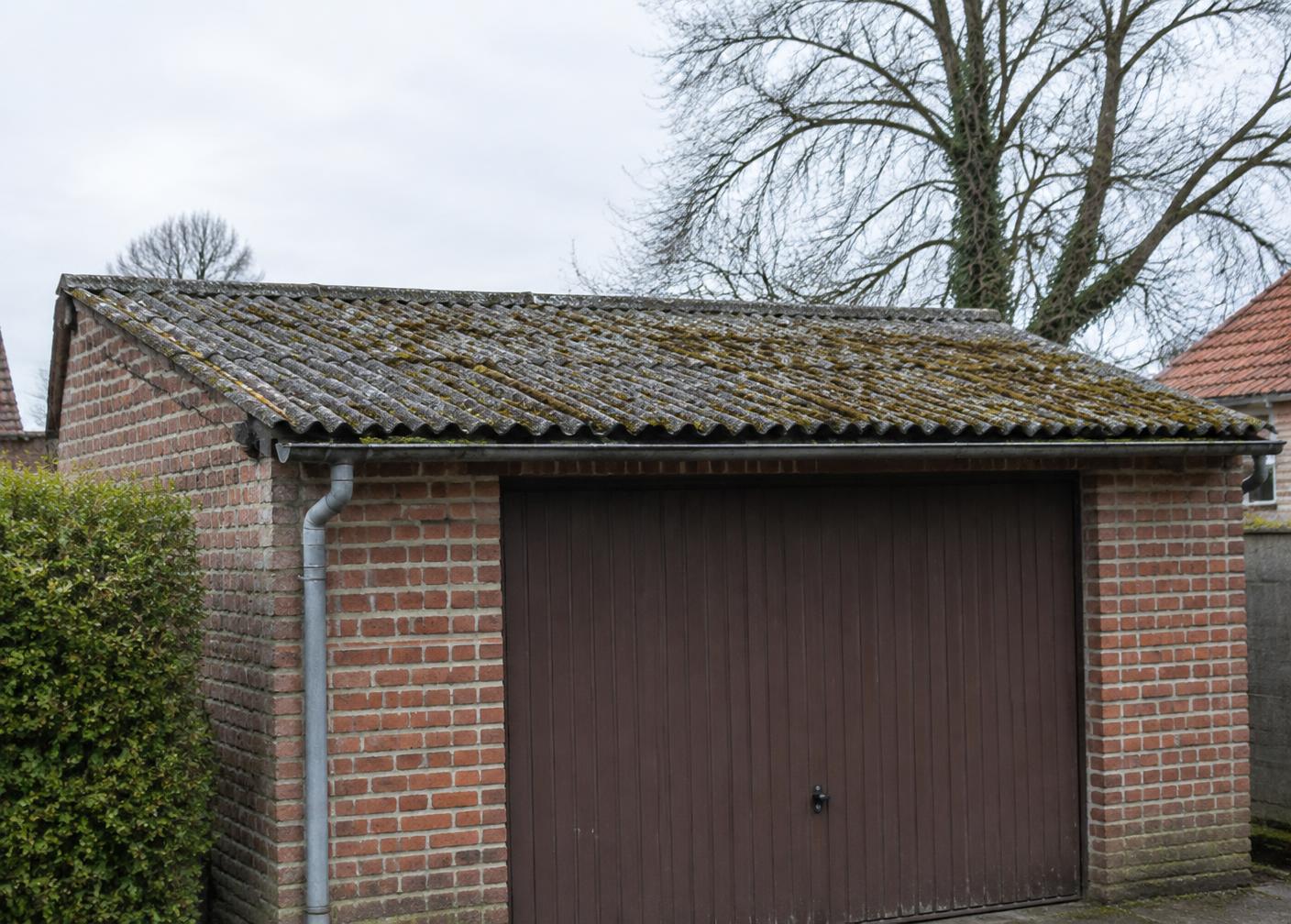 Verouderd golfplatendak in vezelcement op een garage